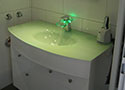 Modernes Waschbecken mit grünem Leuchteffekt
